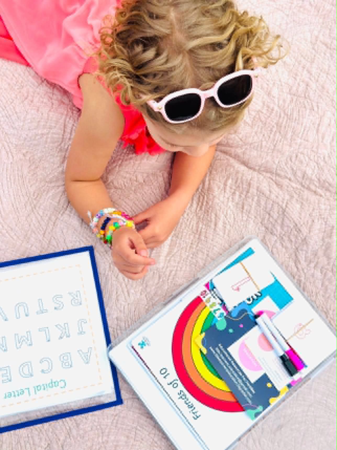 Child playing with capital letters and Friends of 10 boards